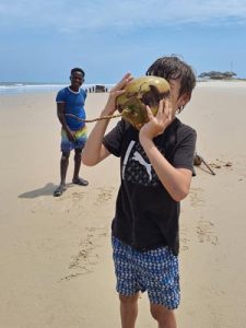 Un jeune homme savourant du jus de coco fraîchement cueilli